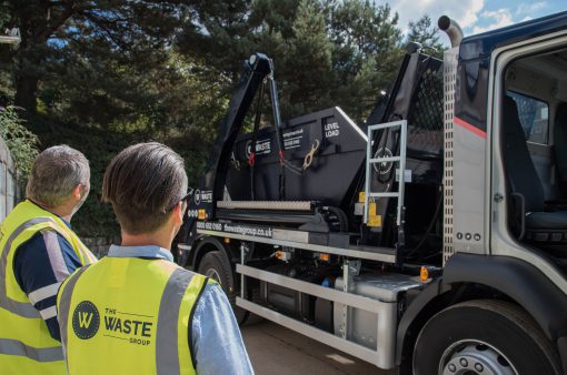 waste group employees standing next to a skip lorry