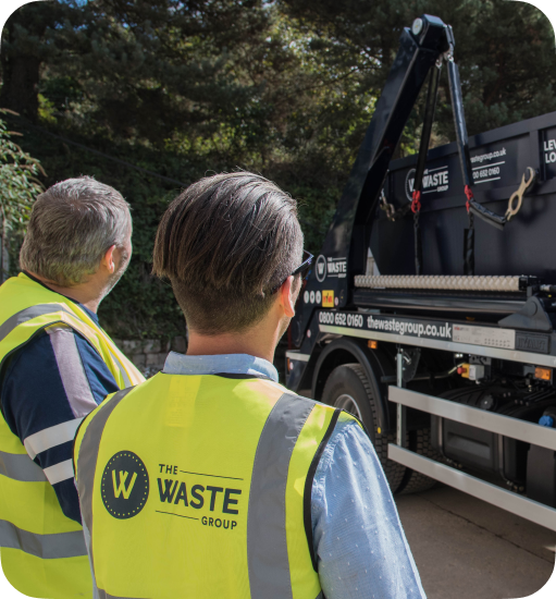 waste group employees loading a skip on a lorry
