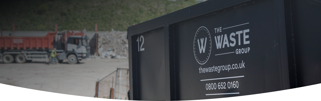 a black skip with the waste group logo