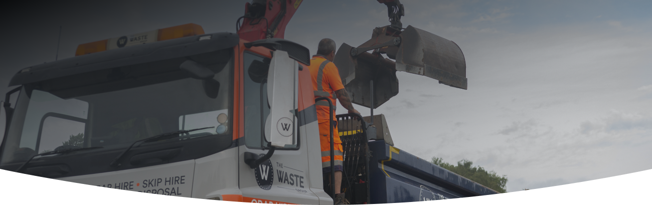 waste group employee standing on a grab lorry