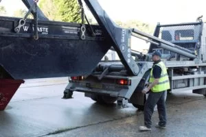 waste group employees loading a skip on a lorry