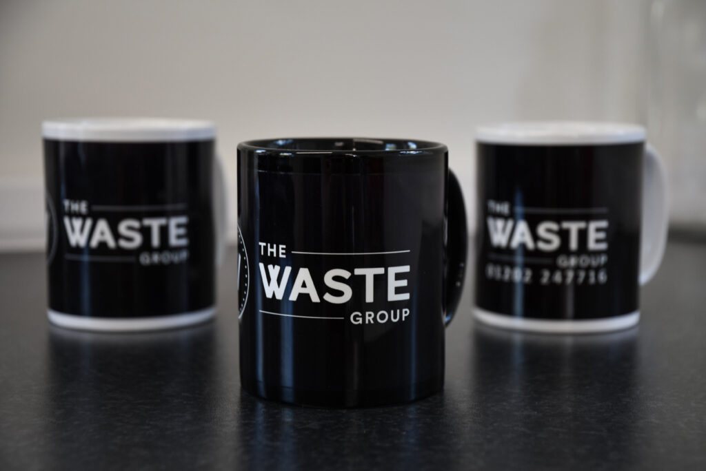 black coffee cups with the waste group logo