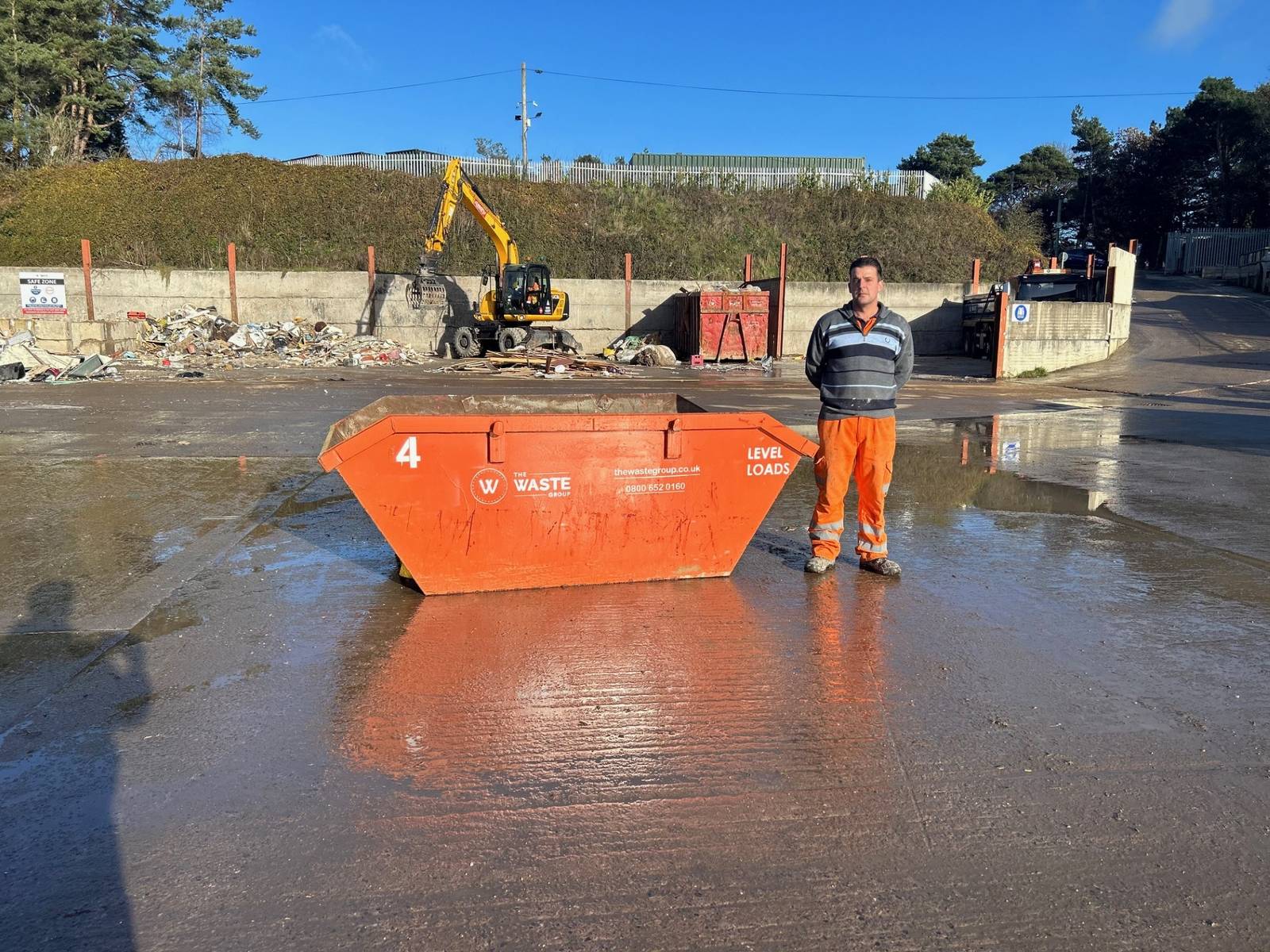 4 yard skip with a person standing beside it for size comparison at The Waste Group