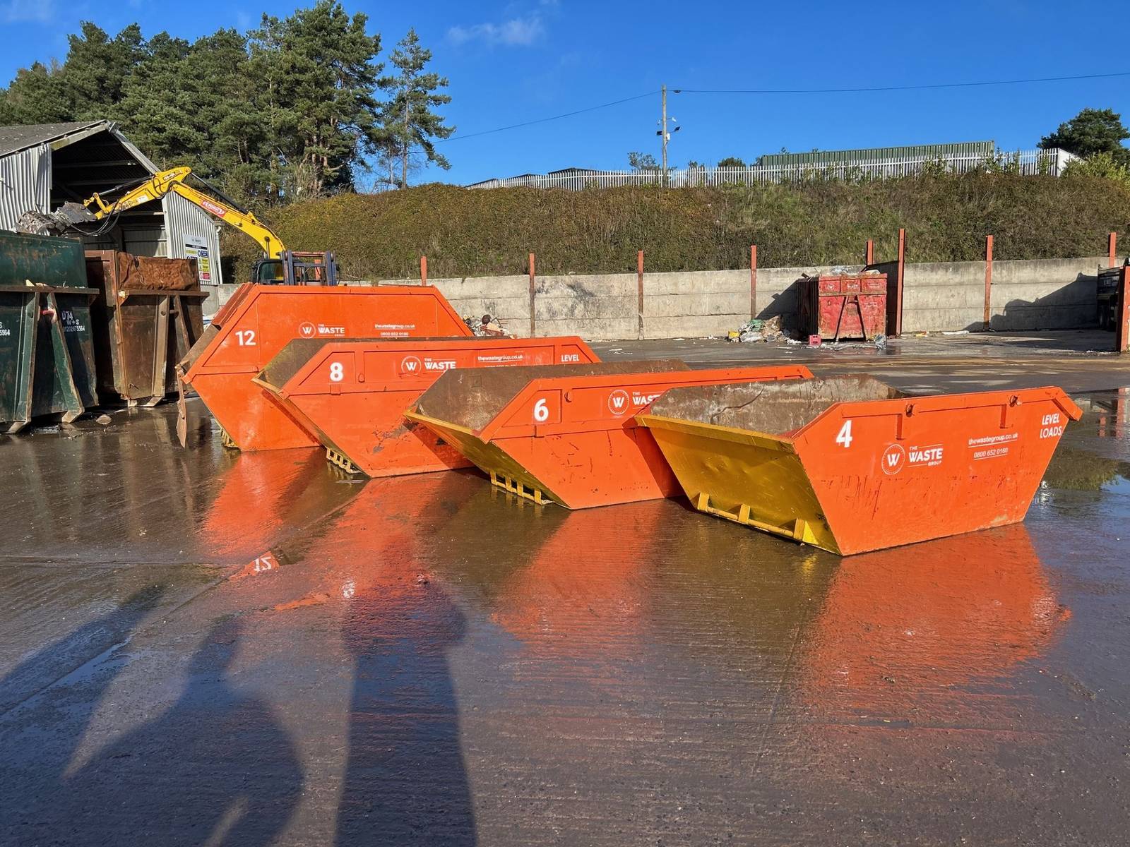Range of skips showing 4 yard, 6 yard, 8 yard, and 12 yard sizes side by side at The Waste Group depot
