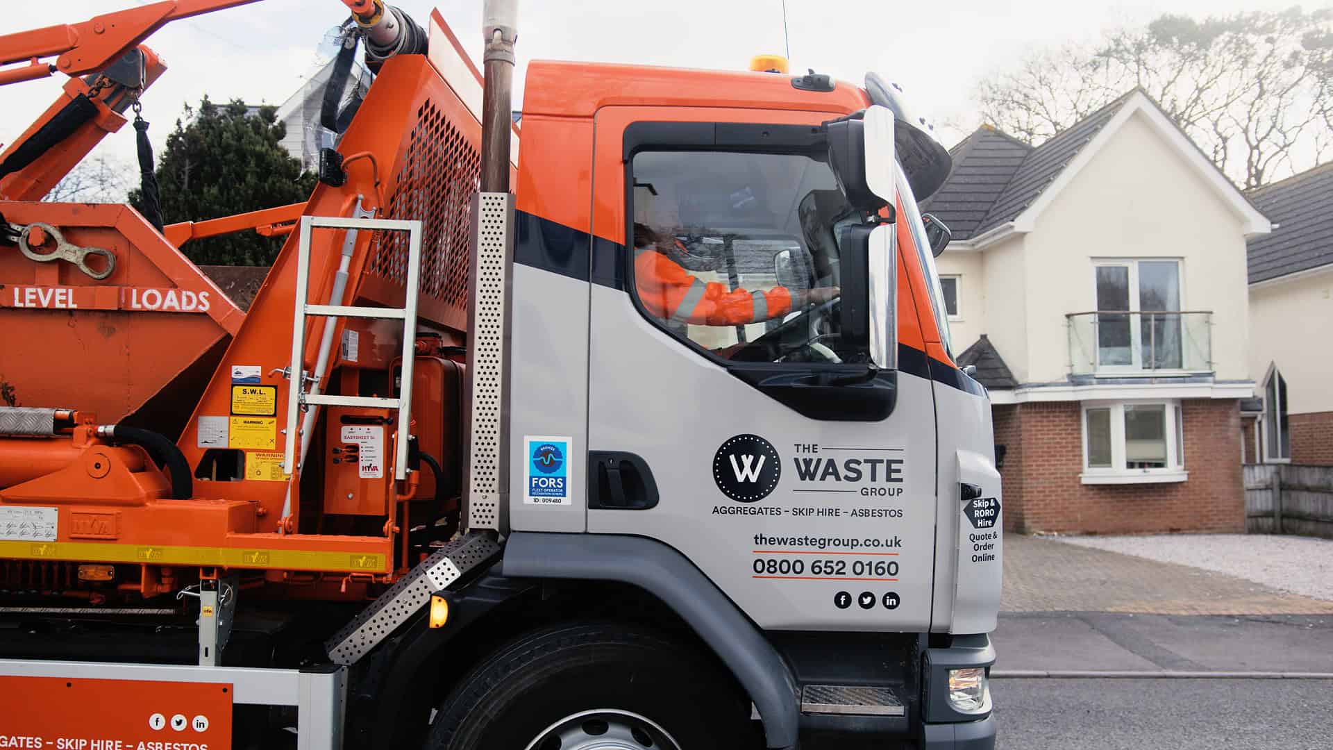 The Waste Group skip lorry delivering an 8-yard builder’s skip to a residential driveway in Poole.